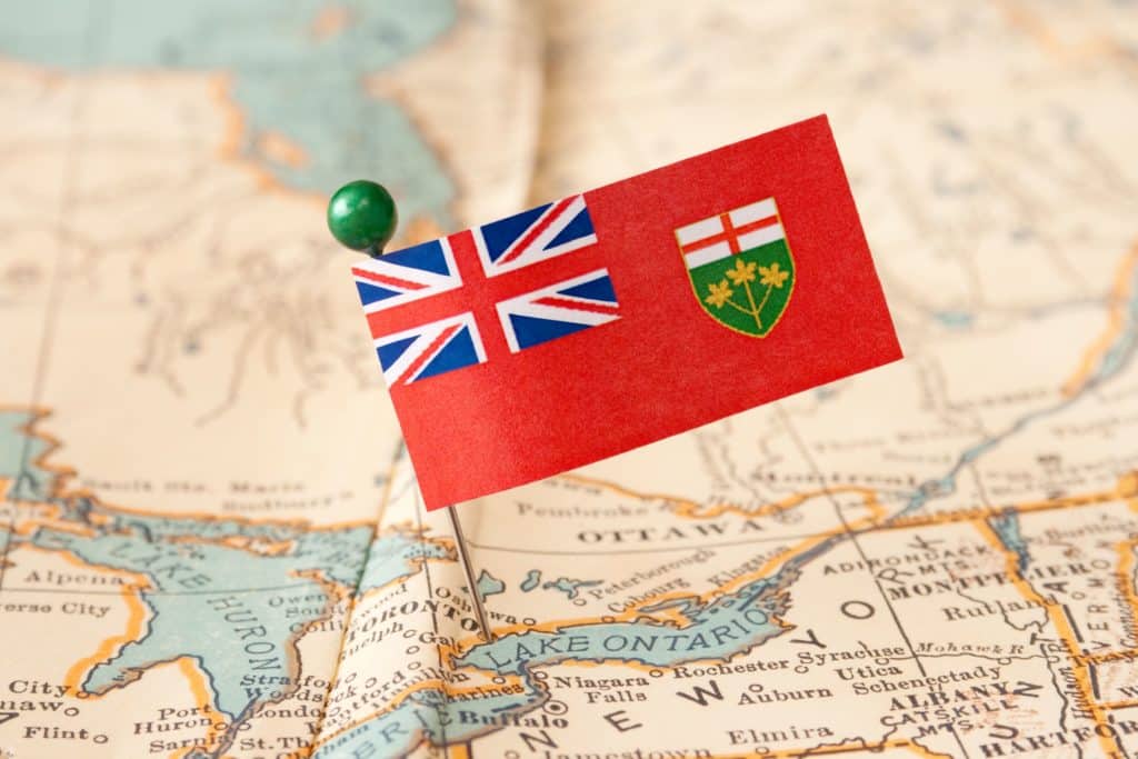 A flag is pinned to a map of Canada.