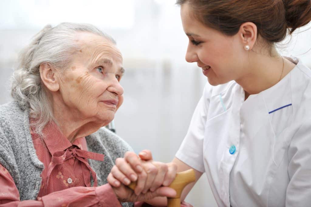 A nurse is providing compassionate care to an elderly Jewish woman at a nursing home.