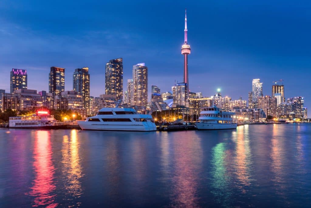 Toronto skyline at dusk with boats in the water and OHIP coverage for seniors.
